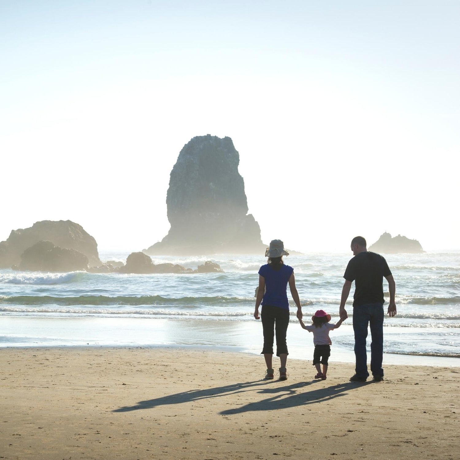 Eine Familie mit Kind spaziert am Strand, inspiriert von MANA'OLANA® – ein Symbol für Geborgenheit, Harmonie und die Verbindung zur Natur.